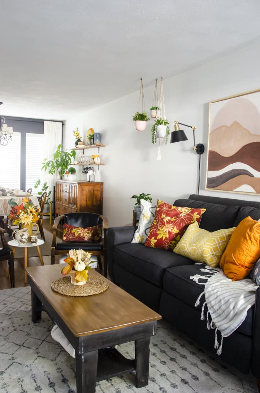 Townhouse living room decorated for Fall with sunflower yellow and floral pillows on the couch.