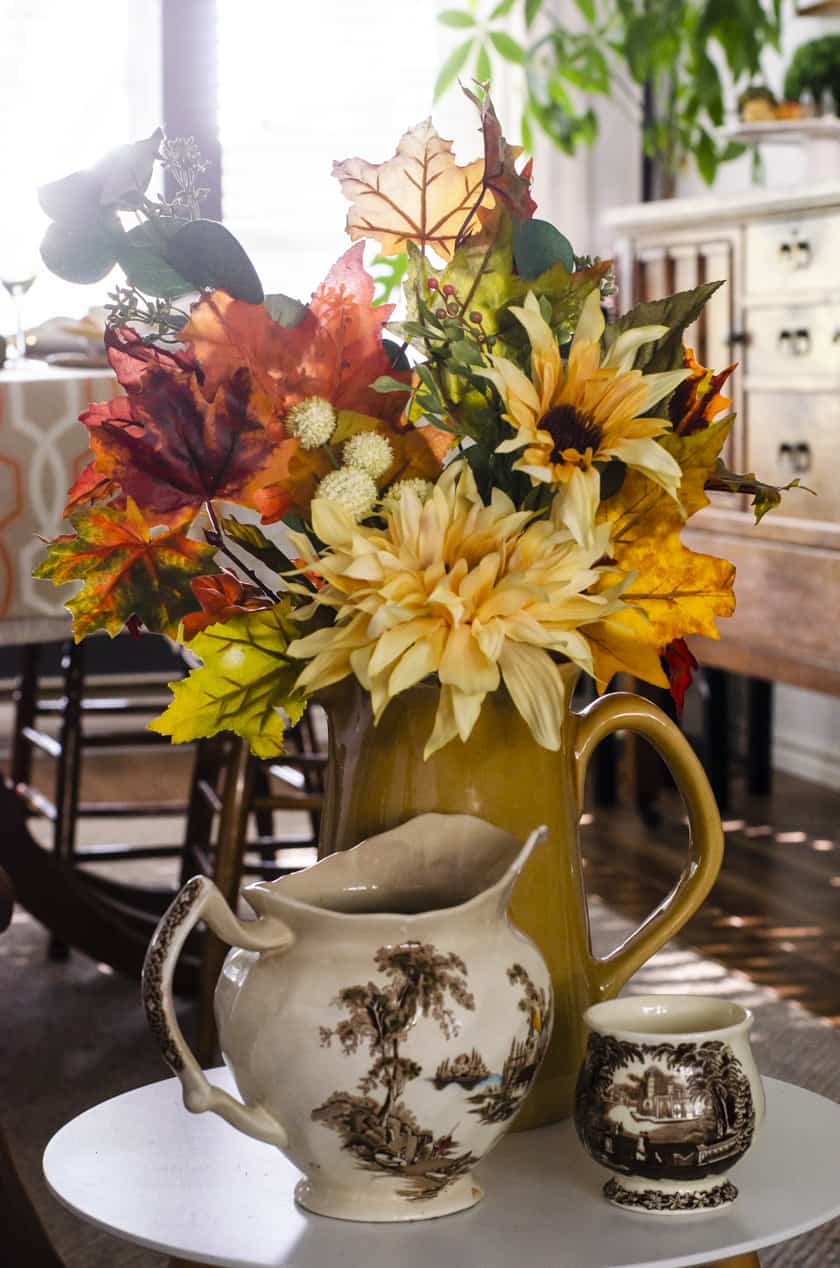 bouquet of fake fall flowers in a pitcher