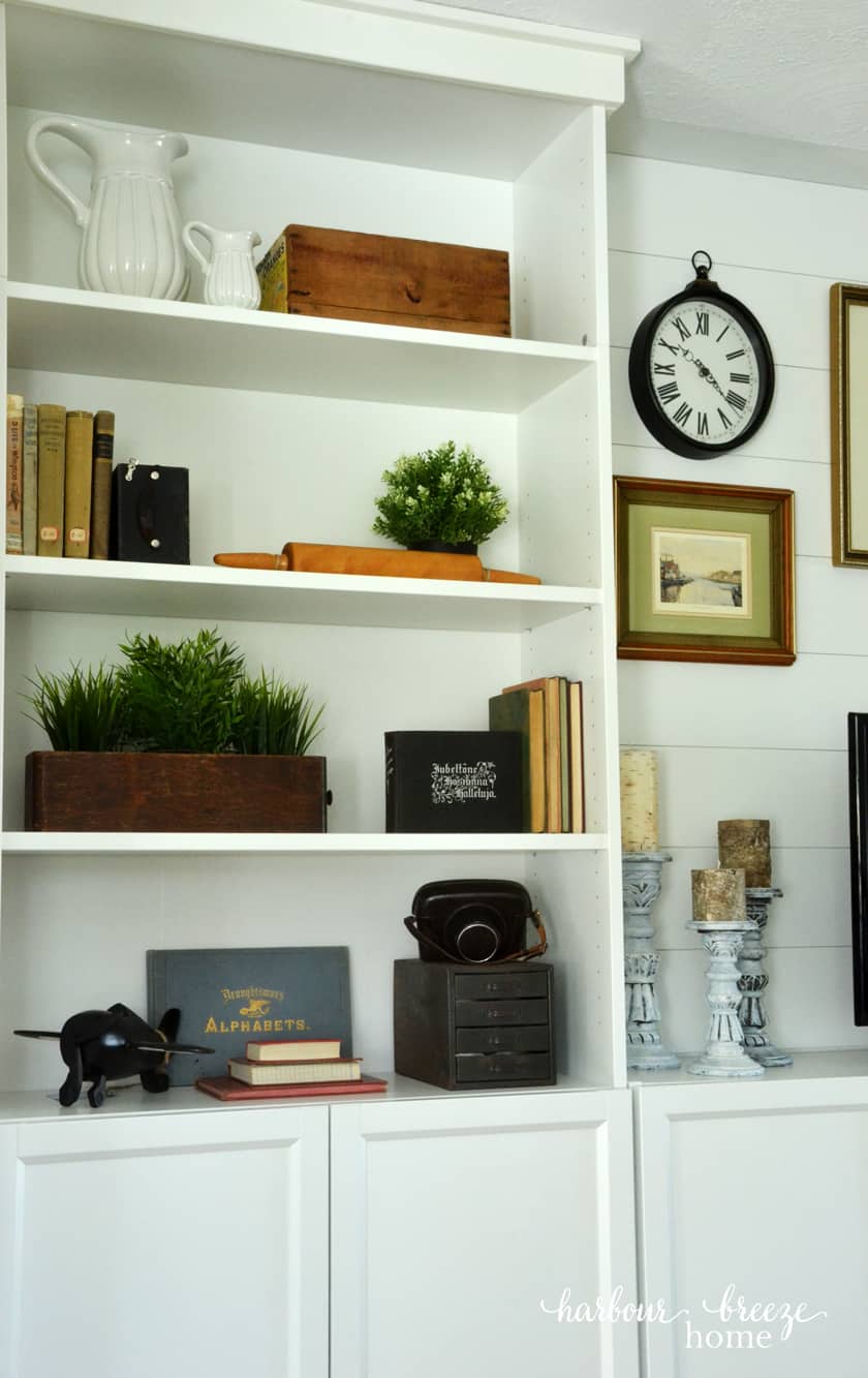 Billy Bookcases with wooden boxes, old books, greenery, and antique cameras