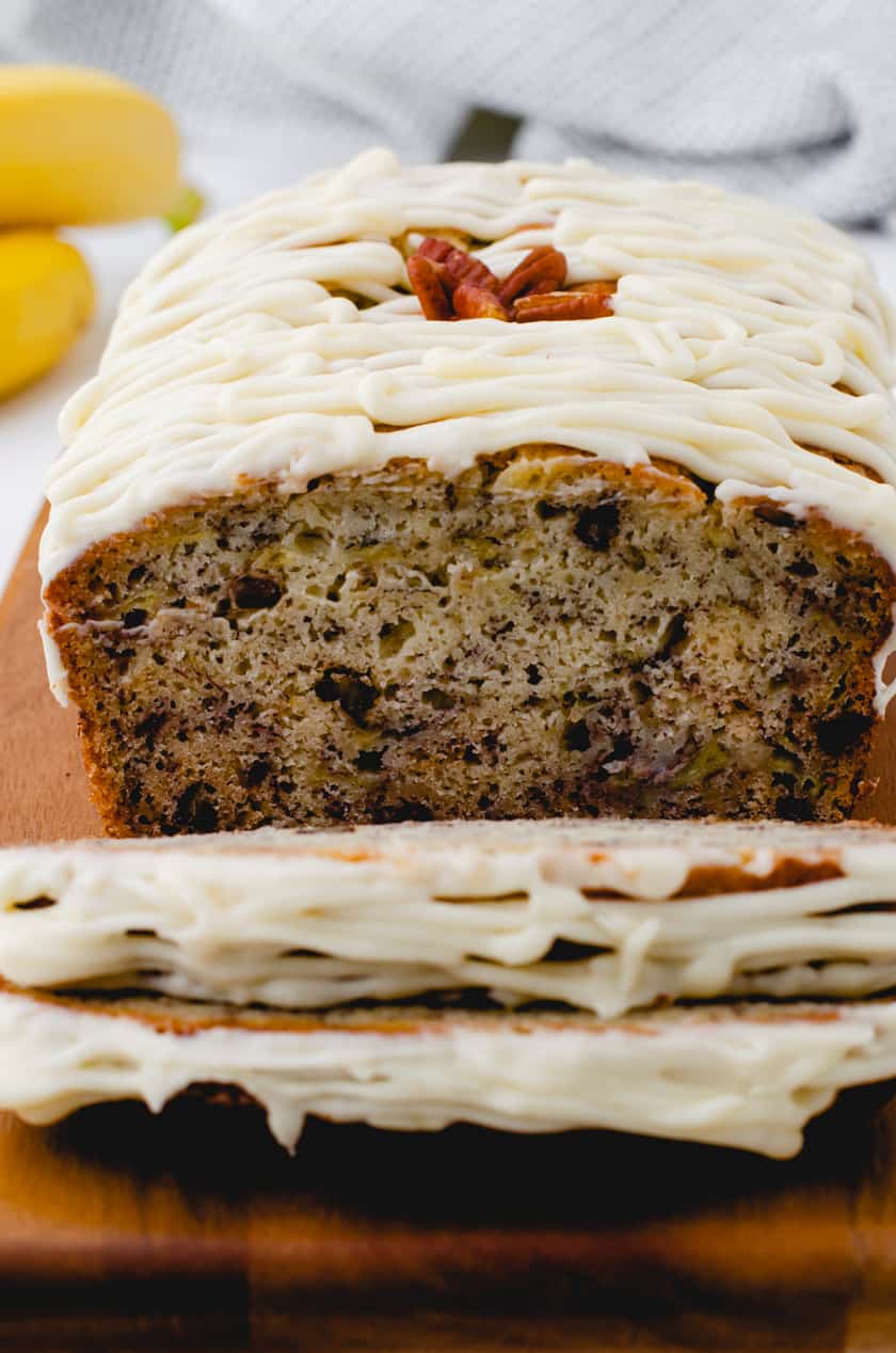 Sliced banana bread with cream cheese icing.