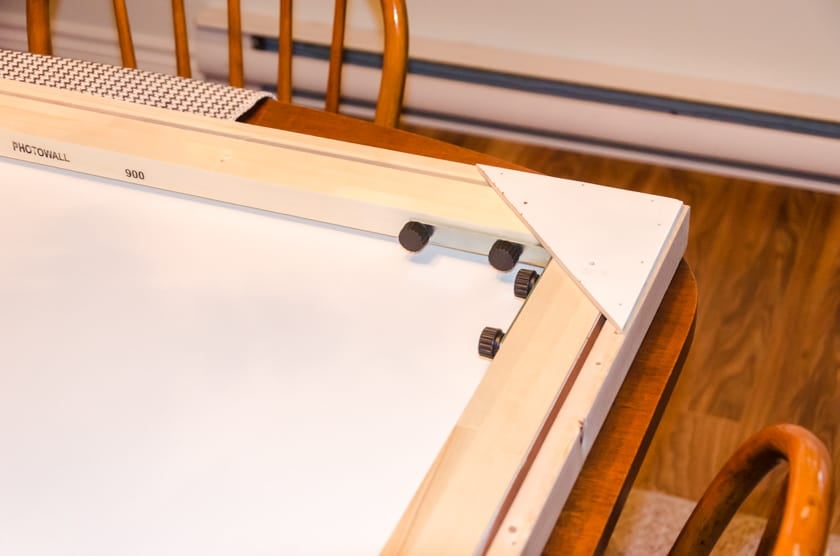 The corner veneer piece attached to the back of a floating frame with canvas art print inside