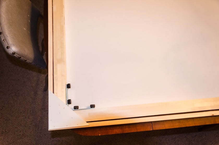 The back side of a canvas with a floating frame showcasing the corner veneer pieces that hold it all together