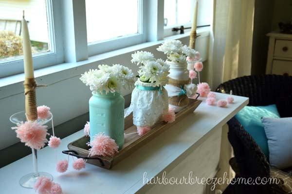 A set of 3 mason jars with white carnations in them