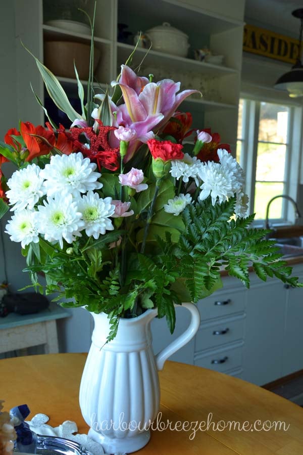 A bouquet of grocery store flowers in a big pitcher.