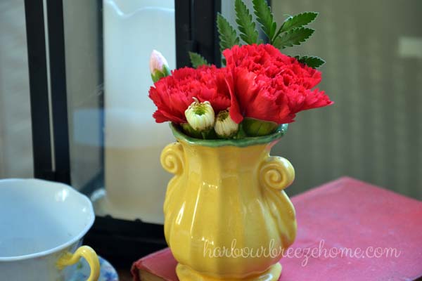 Red carnations in a yellow vase