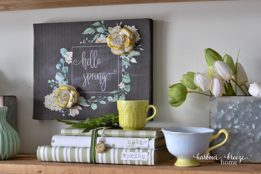 Free printable with flowers on a shelf displayed with spring decor.