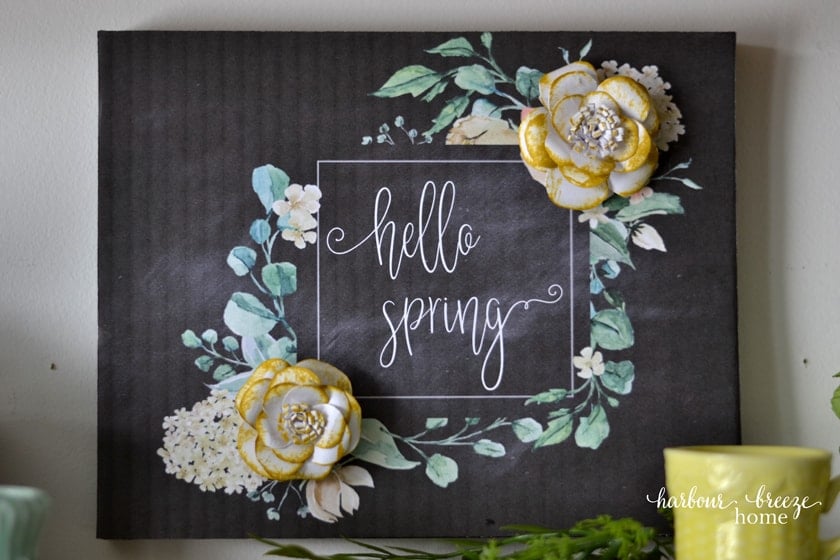 a printable flower art design on a black chalkboard background that says, "hello Spring" with flowers around the text
