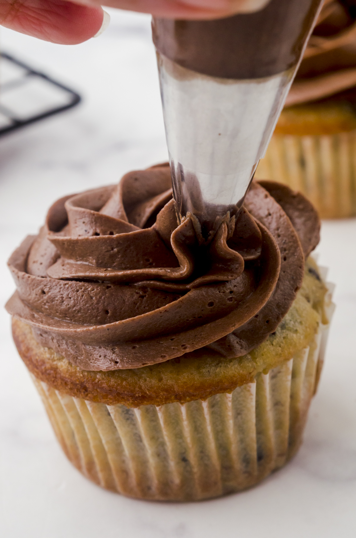 Piped icing covering the top of a cupcake and ending in the center point.