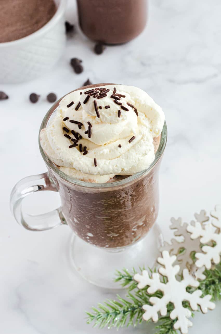 Whipping cream piled on the top of a mug of frozen hot chocolate.