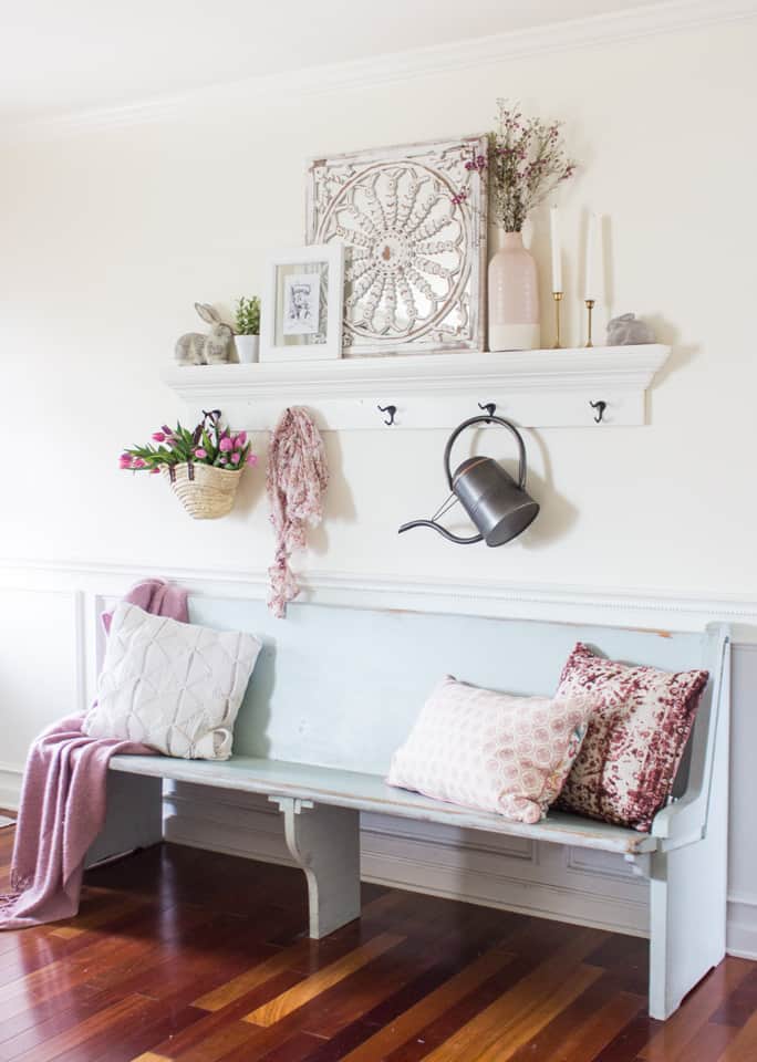 light blue painted church pew with a shelf with hooks above it