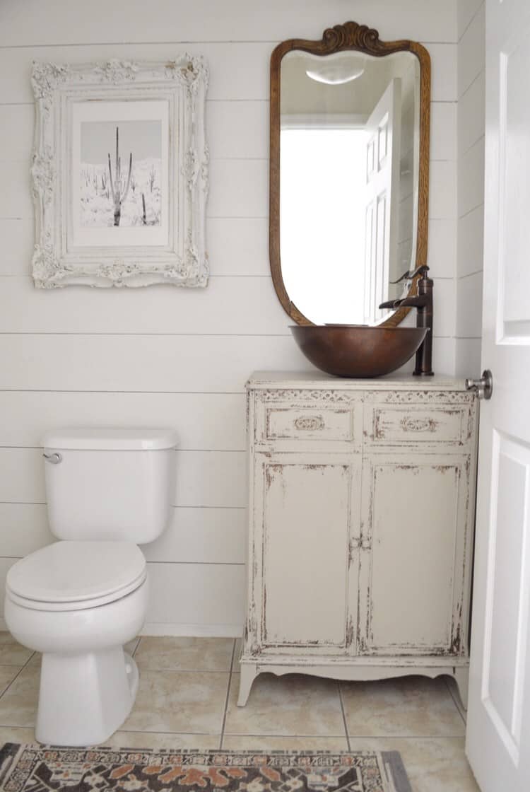 Powder bathroom antique vanity with copper sink and antique mirror