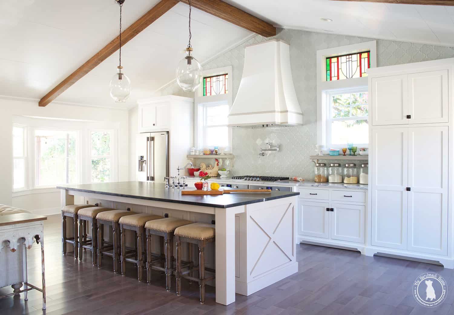 picture of white farmhouse kitchen with a high ceiling with wood beams