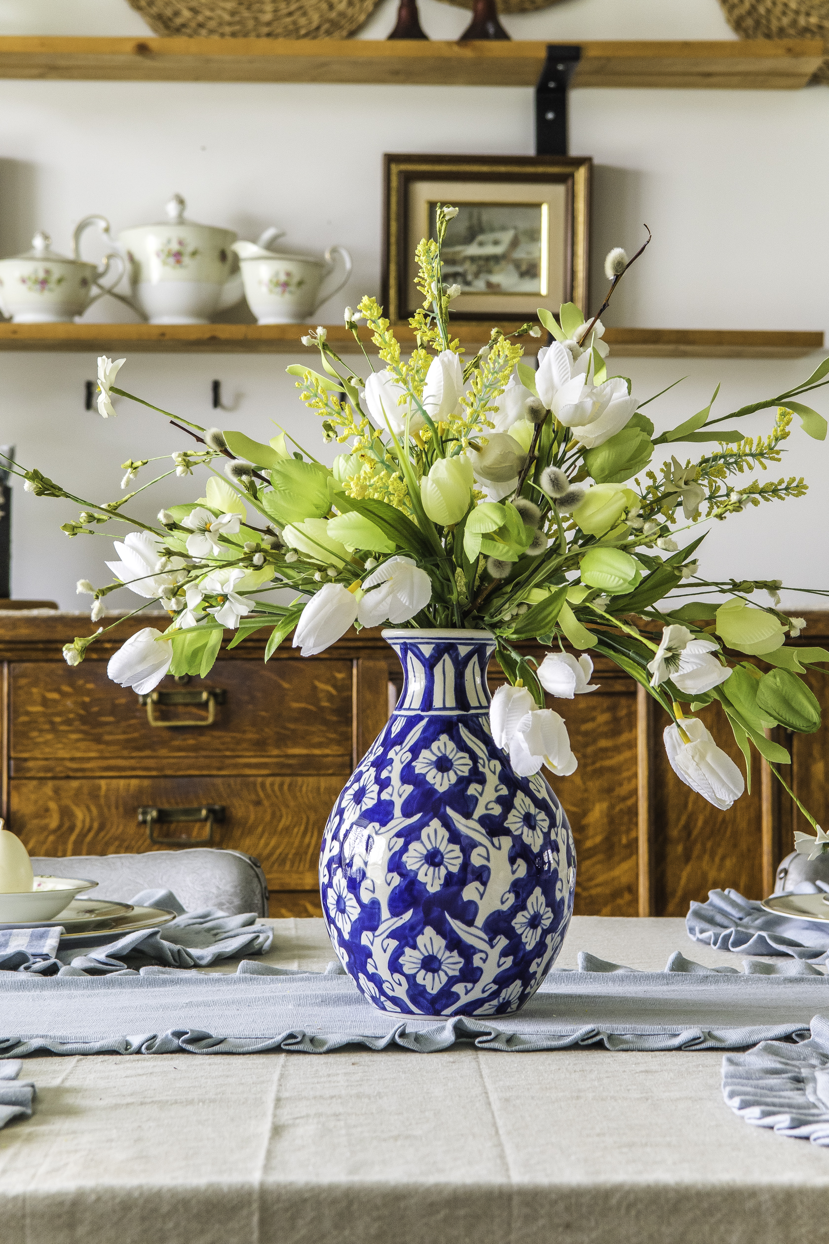 Ginger jar vase with faux tulip arrangment on a table top