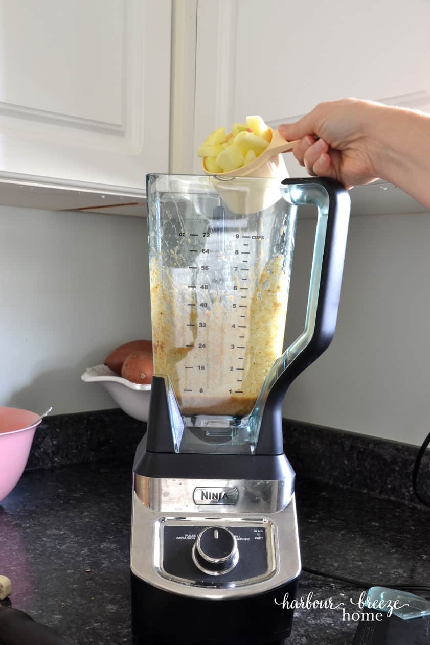 Pouring apple chunks into a blender