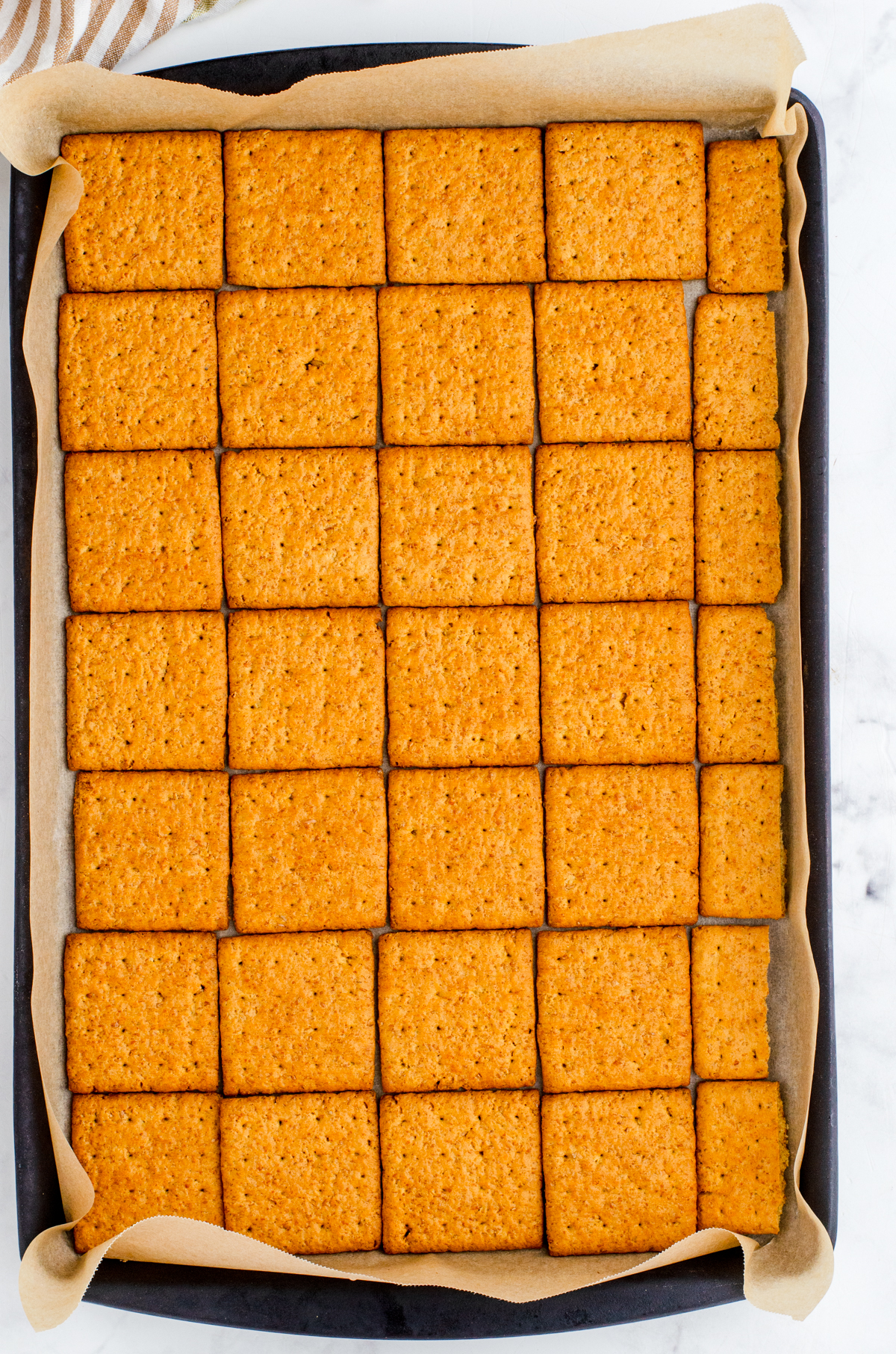 graham crackers lining a parchment lined jelly roll sized pan