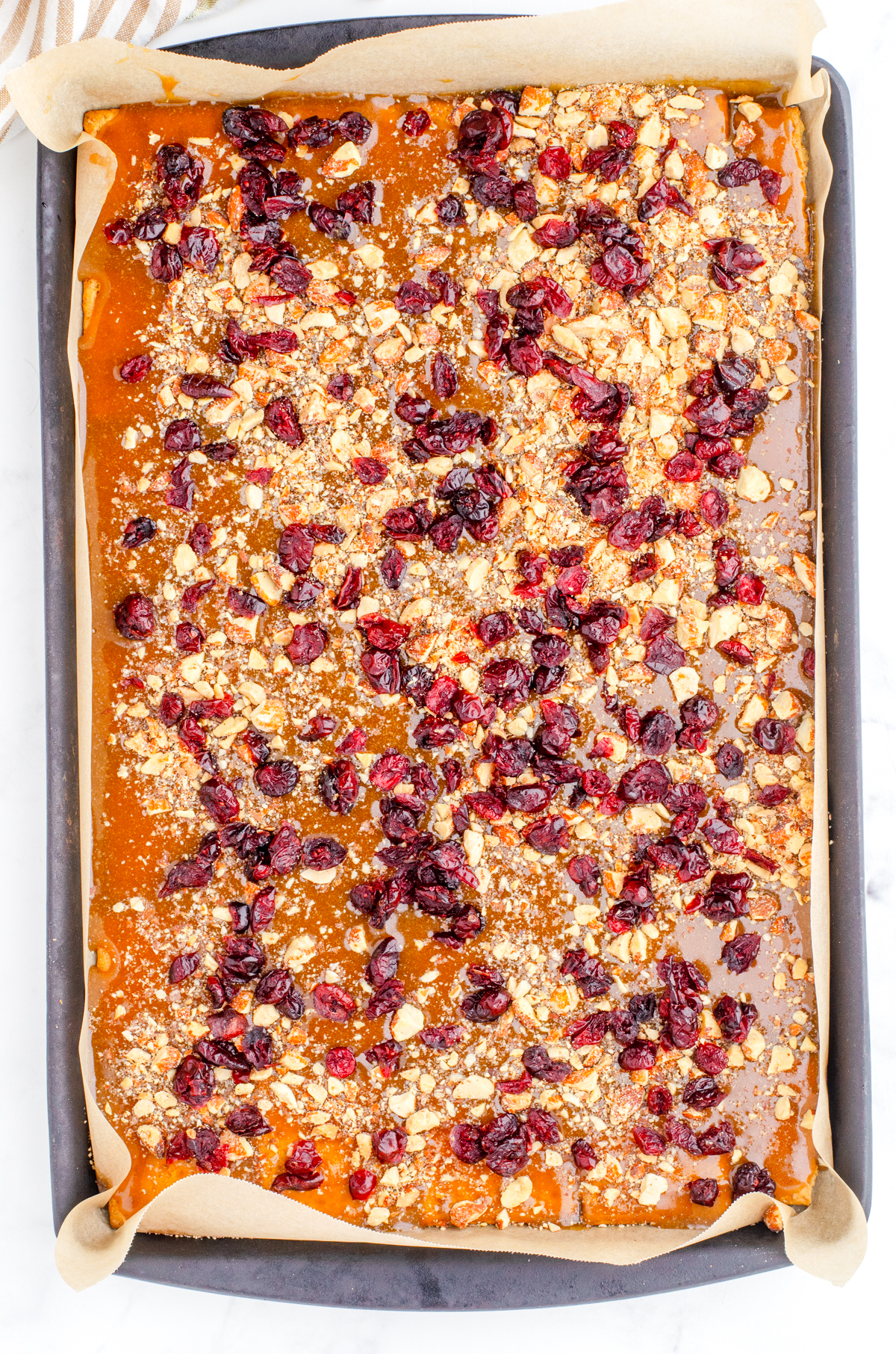 homemade toffee poured over the graham crackers and sprinkled with nuts and craisens