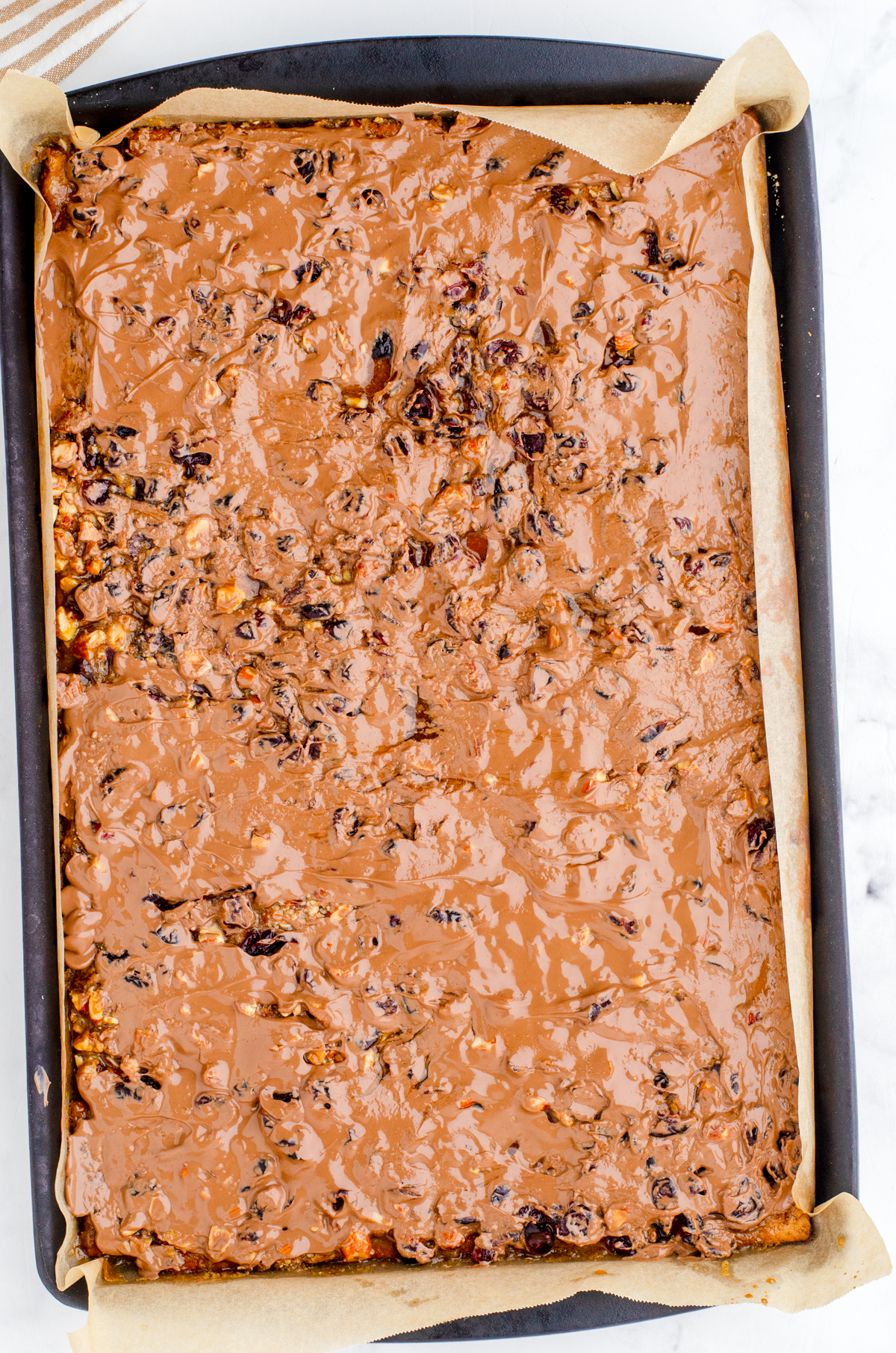 warm chocolate that has just been spread on top of the graham cracker toffee bars