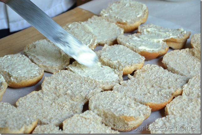 speading mayonnaise on buns for ham and cheese sliders