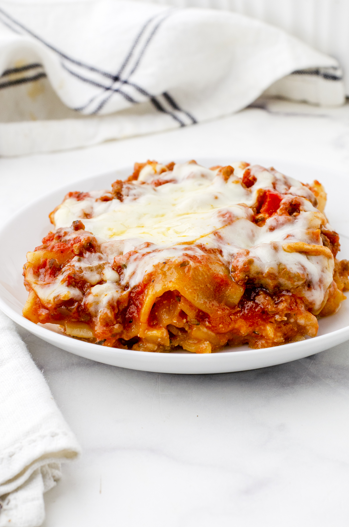 A plate with a piece of lasagna on it.
