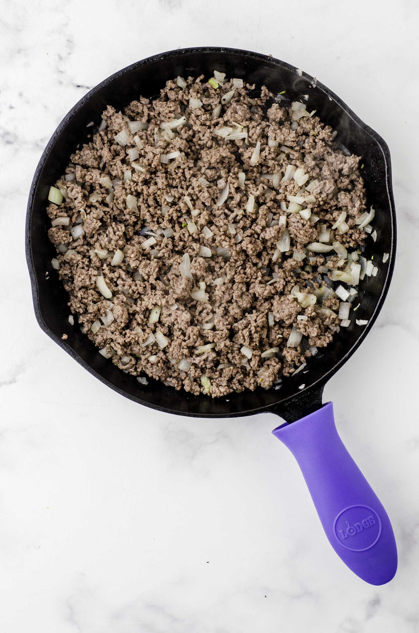 Browned hamburger and diced onions in a cast iron pan