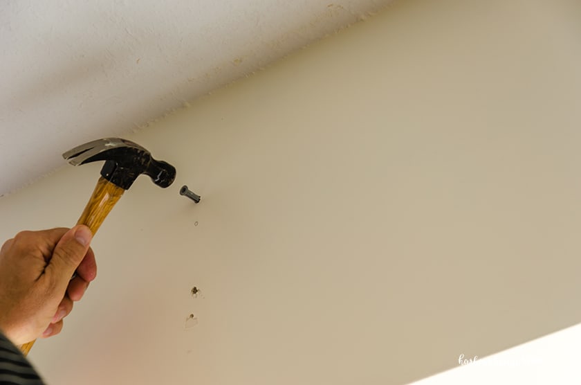 hammering in a wall anchor to attach a curtain rod bracket