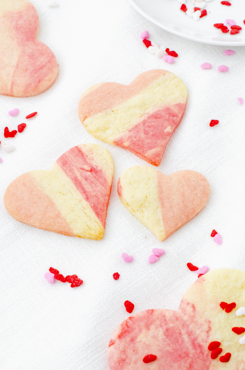 Heart sugar cookies that have marble dough arranged to look like striped cookies.