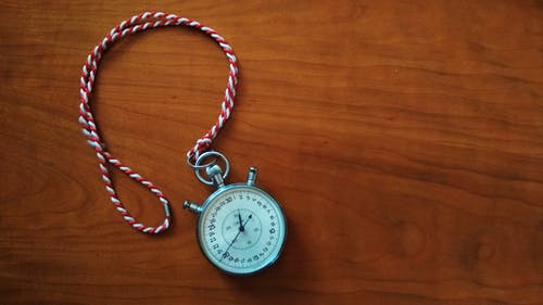 Picture of a stopwatch sitting on a wood surface.