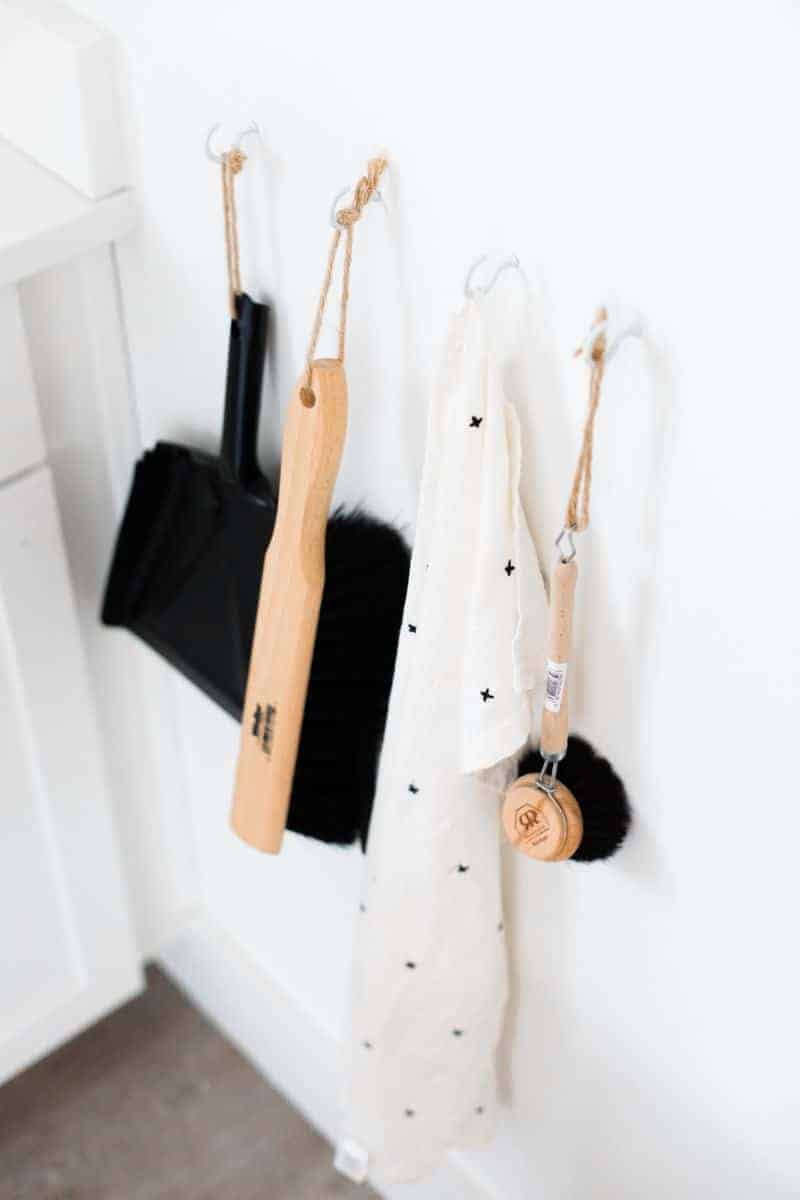 homestyle gathering 3 cleaning tools hanging on hooks on white wall