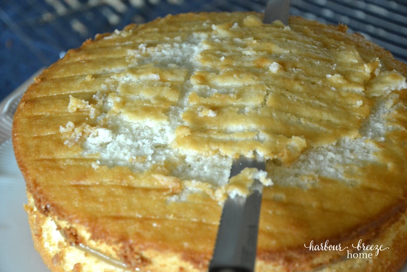 The top cake being flattened by using a large knife to cut off the small "bump" in the middle.