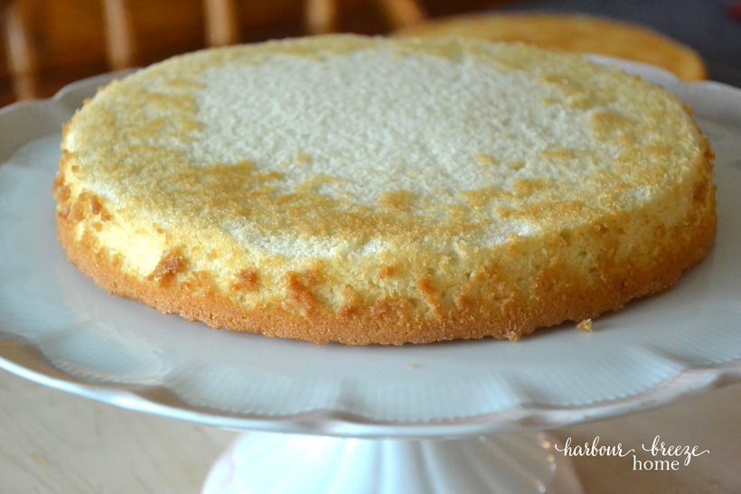 The first layer of a stacked cake on a cake platter.