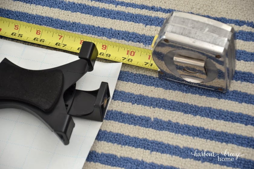 tape measure measuring a sheet of paper to make a gallery wall template