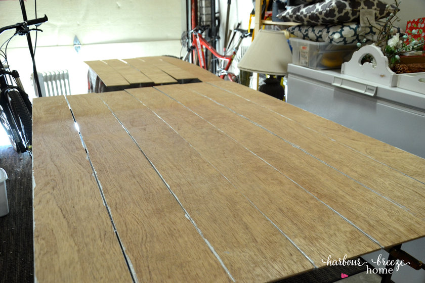 Plywood boards that will be used for DIY Shiplap Wall laid out to be painted.