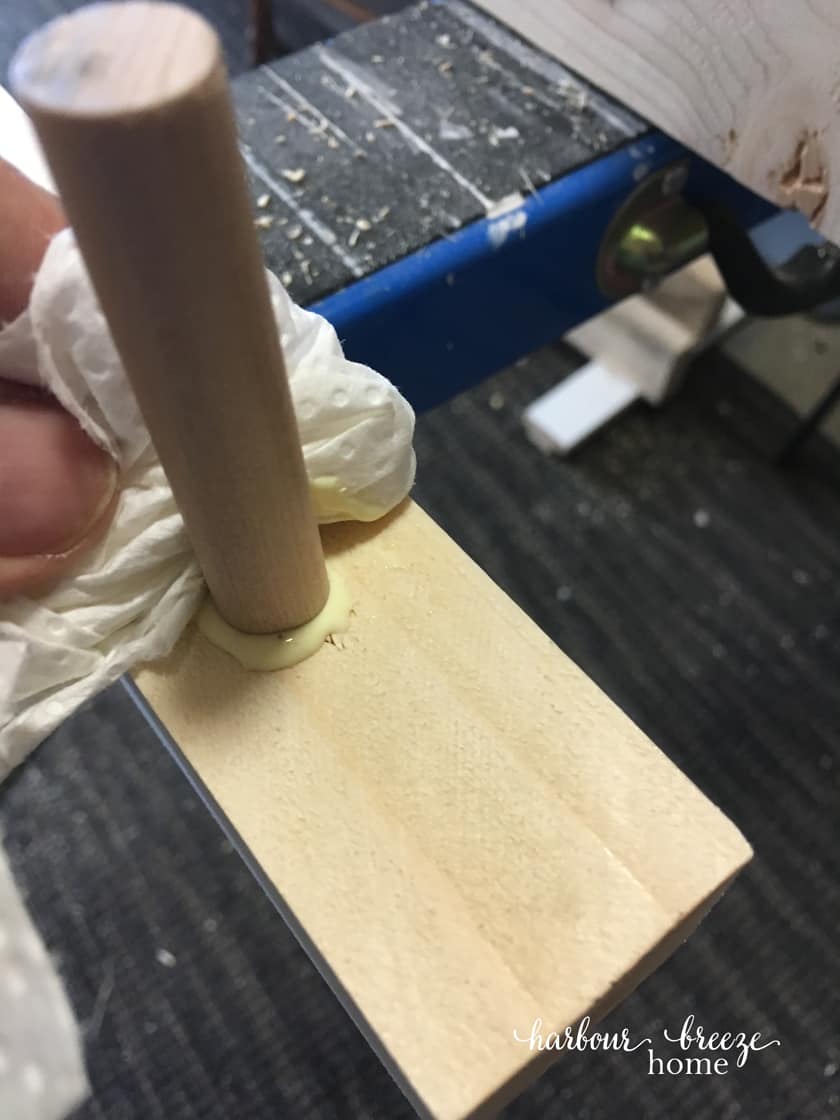 how to make a diy floating shelves - Gluing in the dowel pieces with wood glue and wiping off the excess glue.