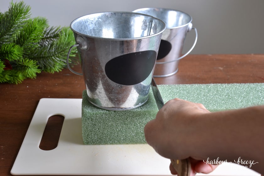 cutting floral foam the size of a small bucket as a base for a little christmas tree