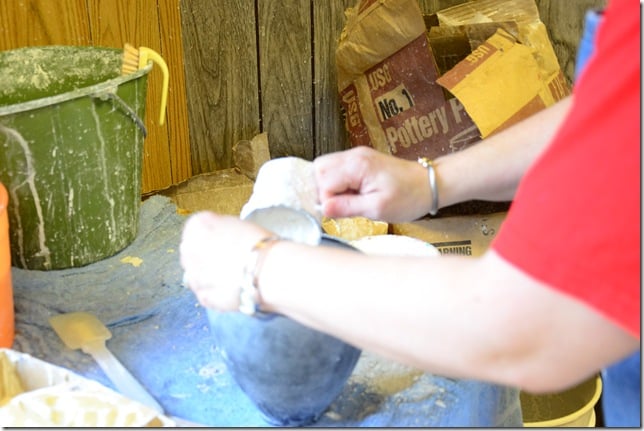 plaster of paris powder being added to water in a rubber pottery mixing bowl