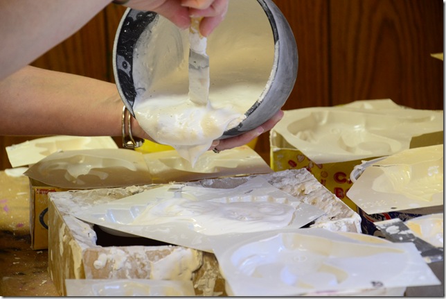 pouring plaster of paris mixture into plaster of paris moulds