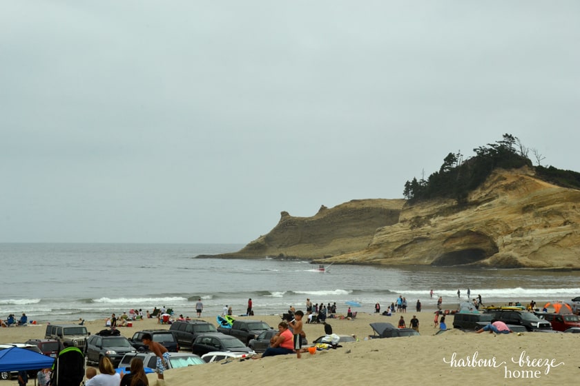 a sandy beach with cars and people on it