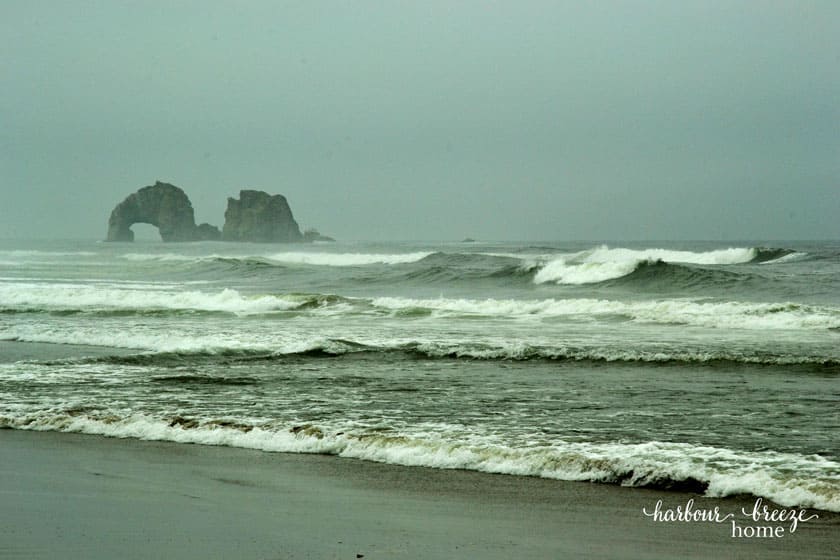 white caps on the ocean with a tall rock standing in the middle