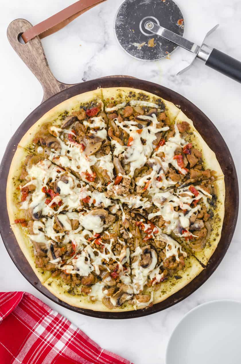 Sliced Sausage Pizza on a pizza stone.
