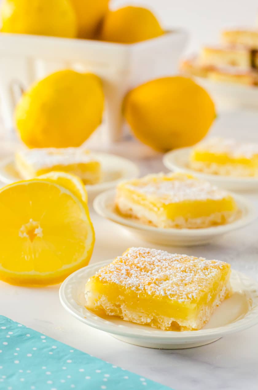Slices of lemon bars on tiny serving plates.