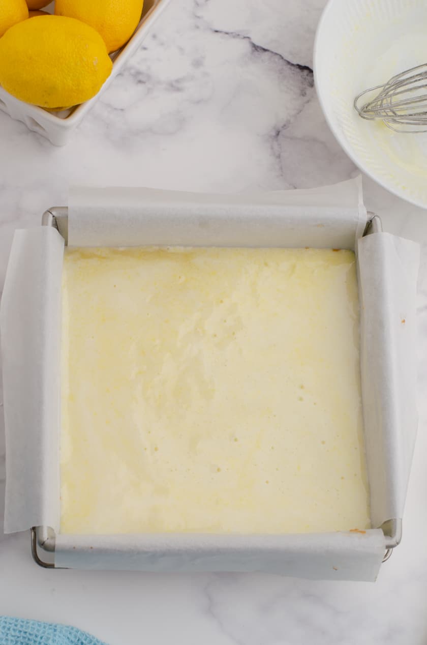 Lemon curd filling on top of shortbread crust ready to be baked.