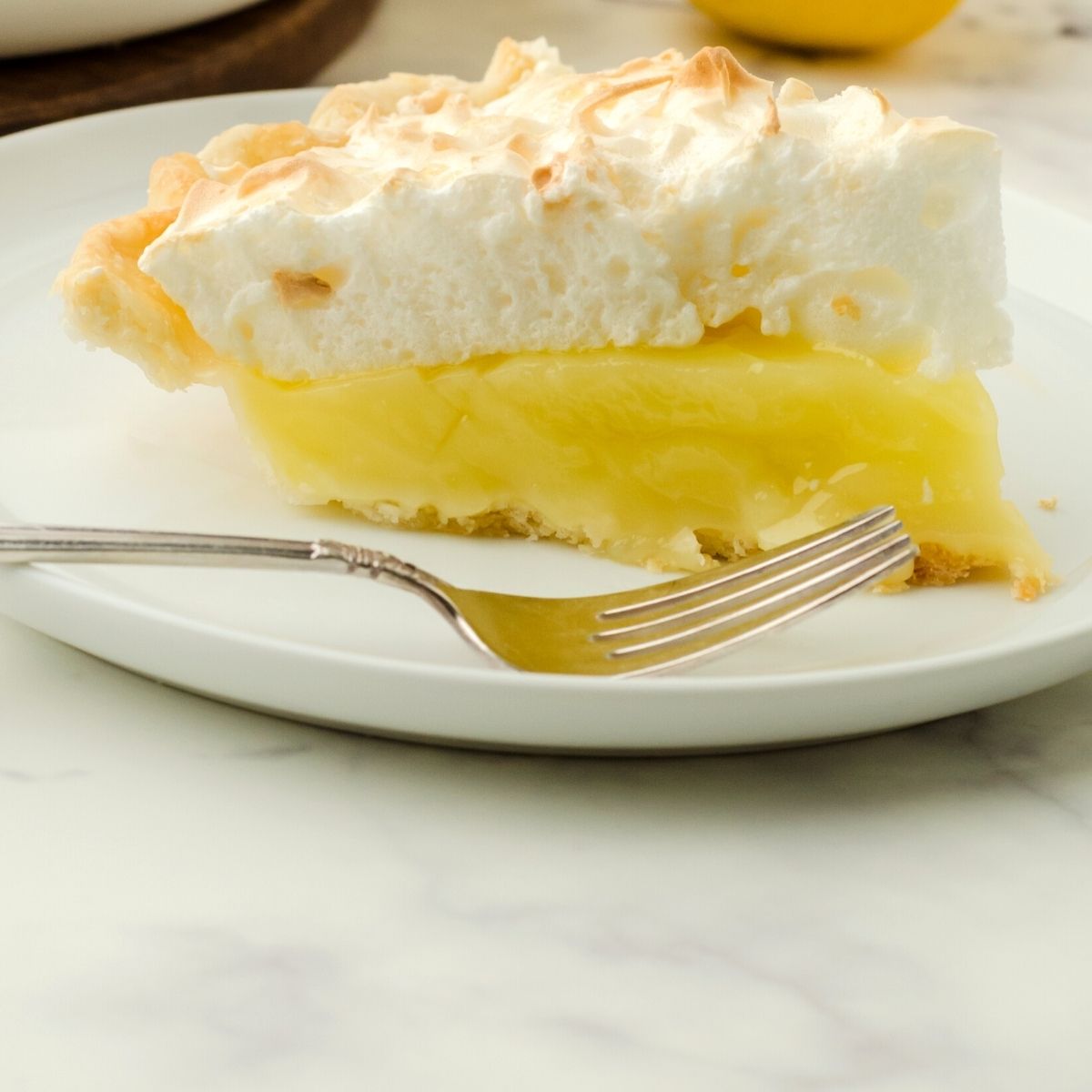 A slice of lemon meringue pie on a serving plate.