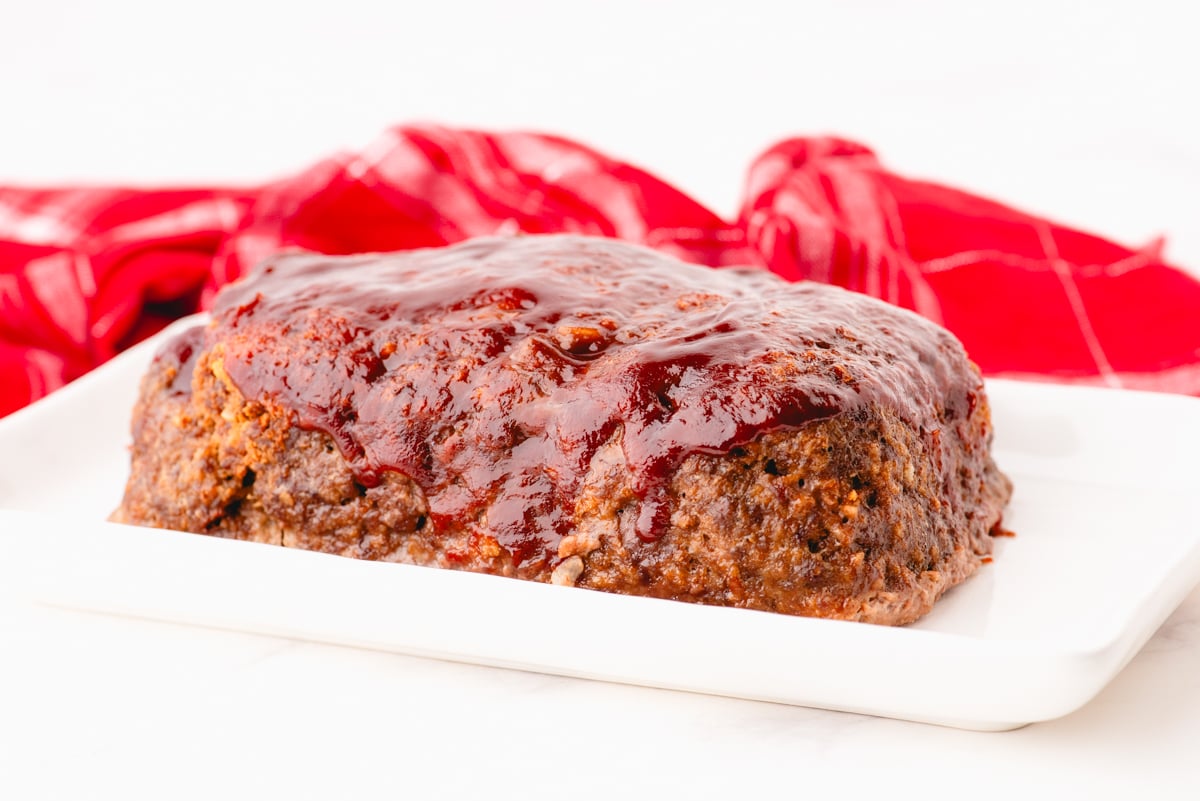 Lipton Onion Meatloaf with ketchup glaze on a platter ready to be cut and served.