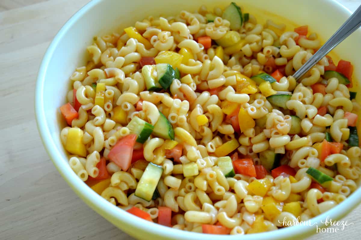 A big bowl of cold pasta salad with ketchup dressing.