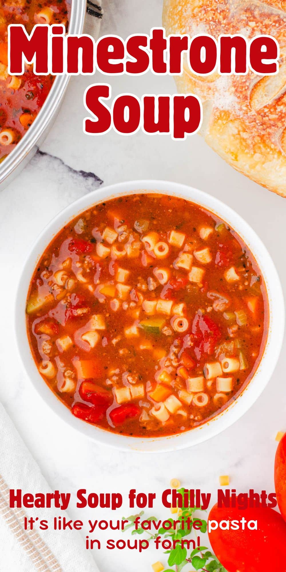 Bowl of minestrone soup with crusty bread beside.