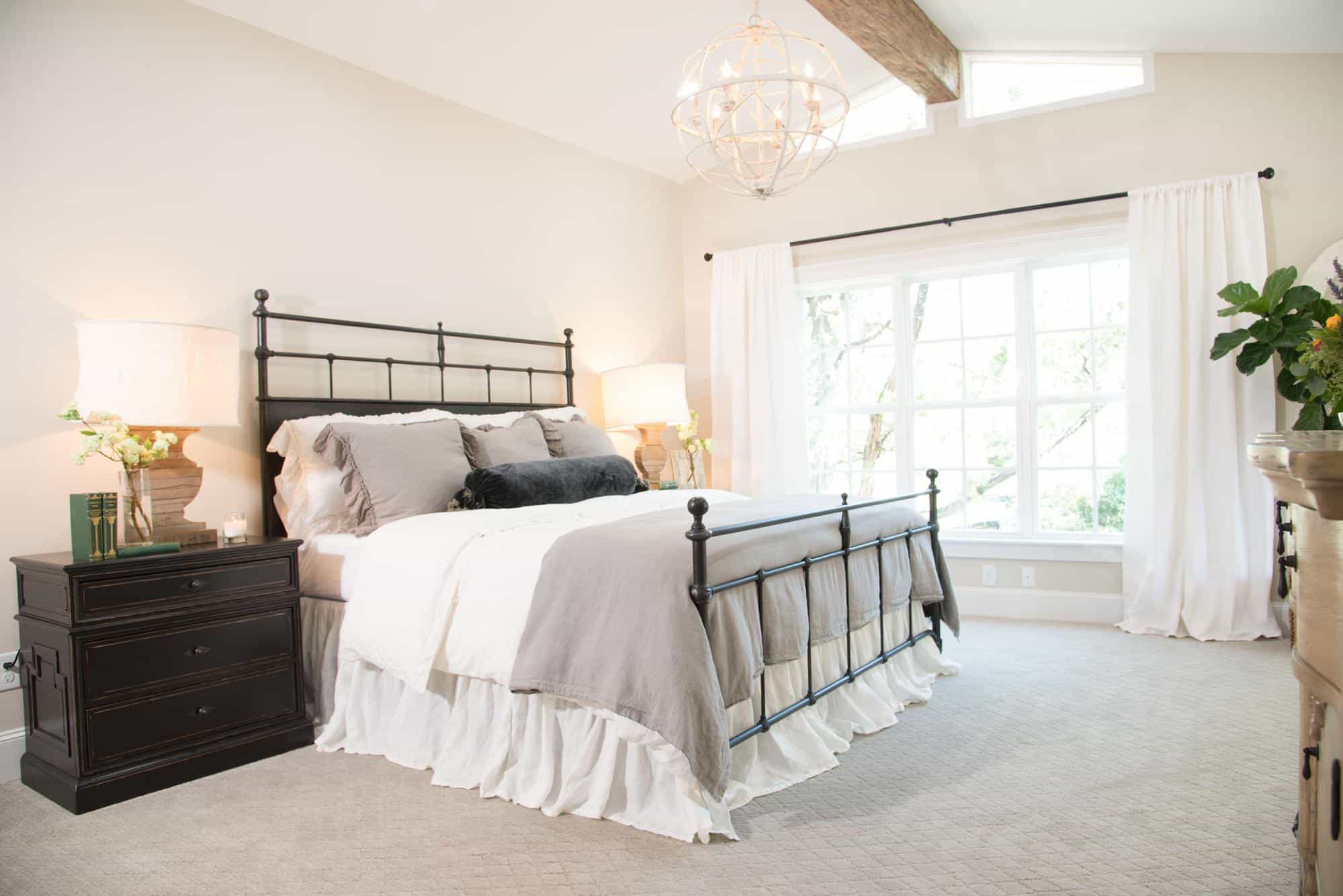 A black metal headboard set against a creamy white wall.