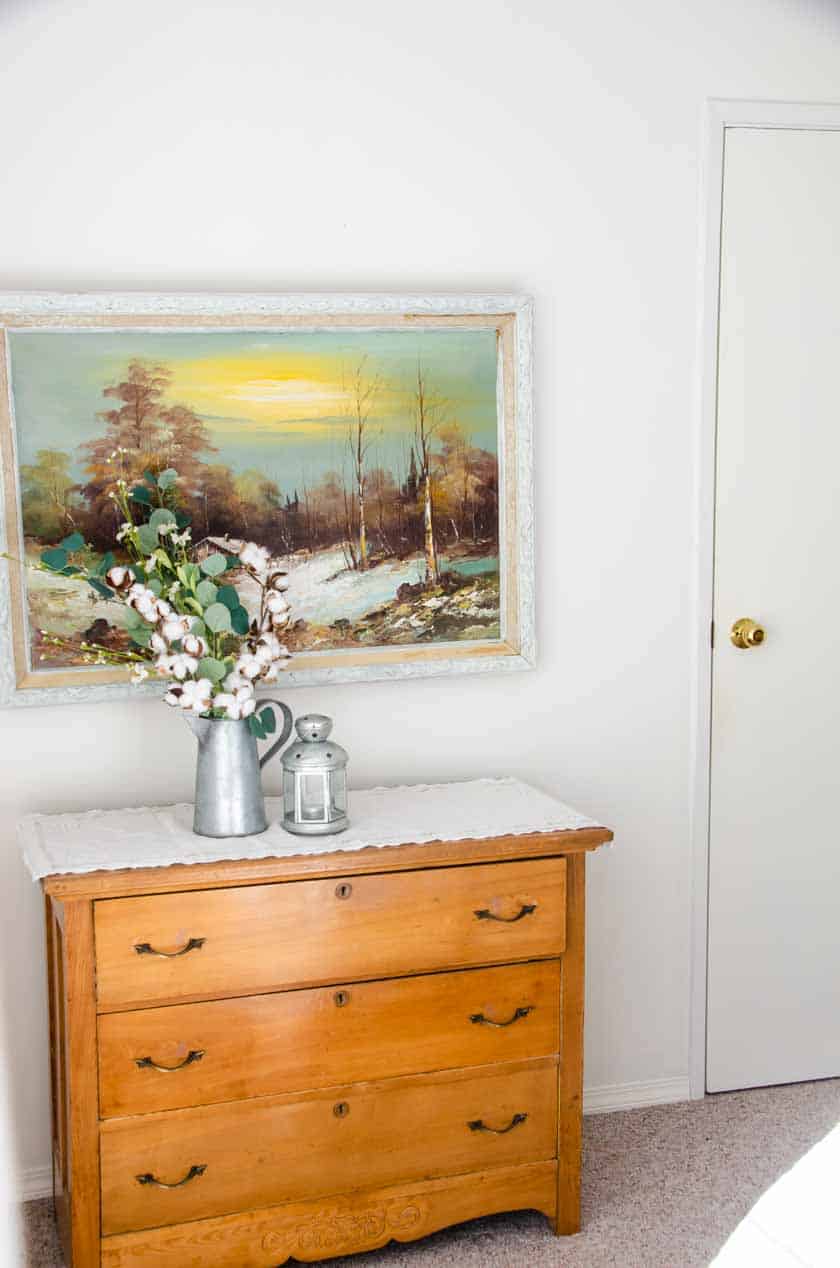 A Wood dresser with artwork above it.