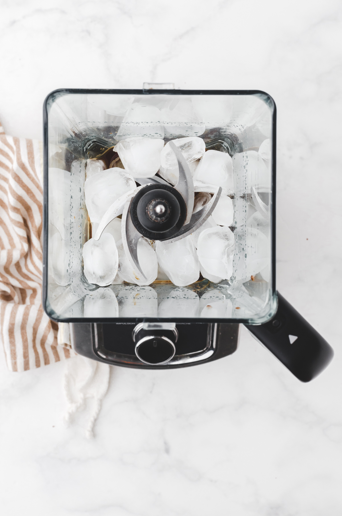 ice cubes added to a blender in preparation for making a nescafe frappe