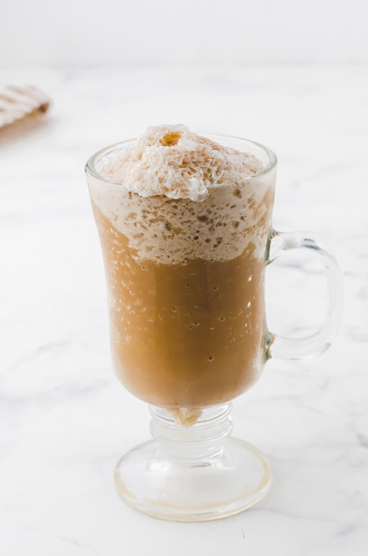 A glass mug with nescafe frappe recipe in it.