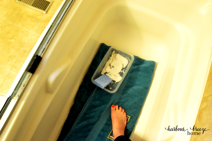 how to clean grout out of shower tiles by standing on a towel in the tub